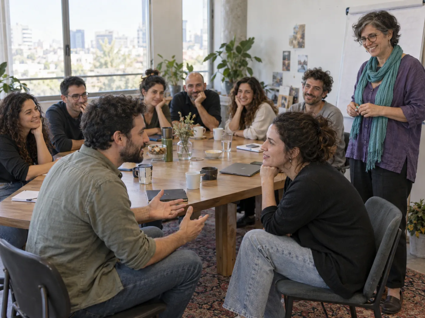 צוות עבודה יושב סביב שולחן בסדנה ומתרגל בזוגות